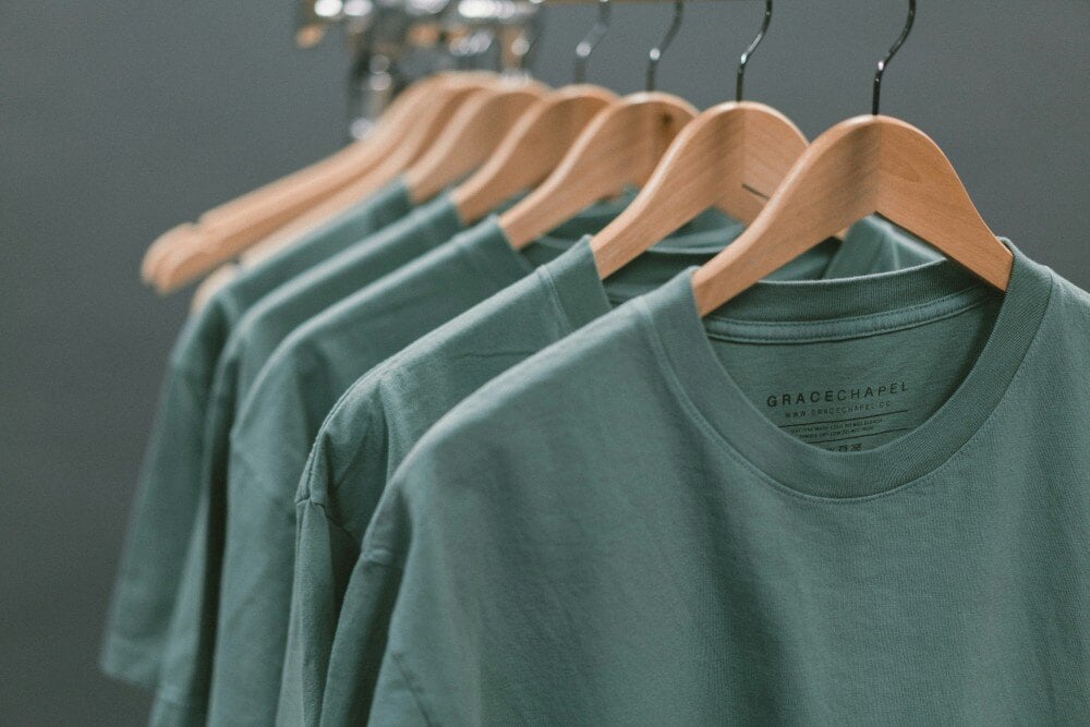 Row of green t-shirts on a rack