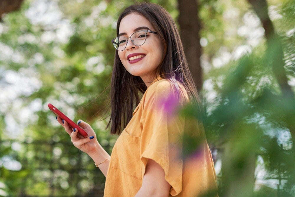 Woman holding phone and smiling