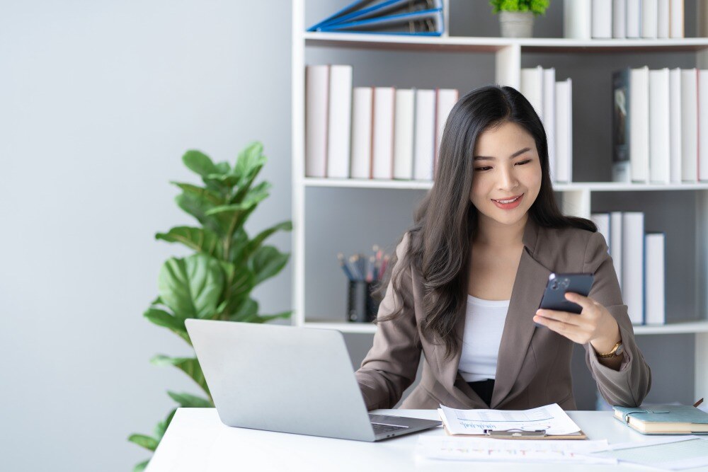 Woman using mobile phone and  laptop